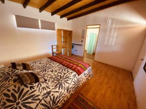 圣佩德罗·德·阿塔卡马Atacama Checar, Hostal的一间卧室配有一张床,铺有木地板