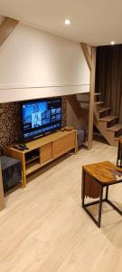 凯恩Antares - SILS --- 2 chambres séparées en mezzanine的客厅设有大屏幕电视和楼梯。