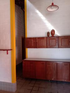 嘎林海斯港CASA EM PORTO的空的厨房,配有木制橱柜和黄色的柱子