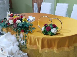 Hanul Anitei La paducel的黄色的桌子上放着鲜花,上面有环