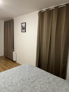 沙勒罗瓦Wauters 77 Bruxelles -charleroi-airport的卧室配有灰色窗帘和一张床