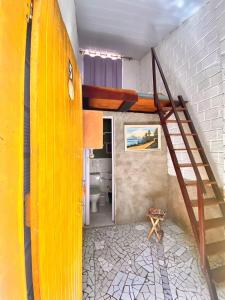 拉巴拉德纳圣米格尔Natus Hospedagem的客房设有黄色楼梯和浴室