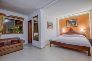 卡塔赫纳Baluarte Cartagena Hotel Boutique的一间卧室配有一张床和一张沙发