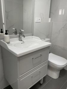 瓦伦西亚Maison Sereine的白色的浴室设有水槽和卫生间。