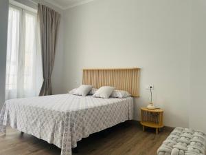 瓦伦西亚Maison Sereine的卧室配有带白色棉被的床