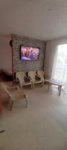 弗兰德斯Apto Flandes Tolima的客厅配有椅子和砖墙上的电视
