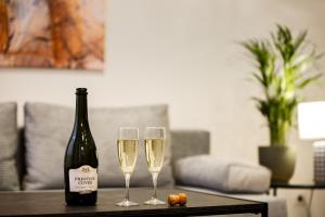 里加RIGAAPARTMENT ELIZABETES 22 Self-Service Aparthotel的桌子上放有一瓶香槟和两杯酒杯