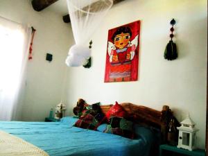 拉佩德雷拉Rico Pino eco posada的卧室配有一张床,墙上挂有绘画作品