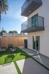 洛杉矶Normandie Hostel的带阳台和草地的后院