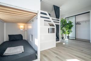 洛杉矶Normandie Hostel的一间卧室设有双层床和楼梯。