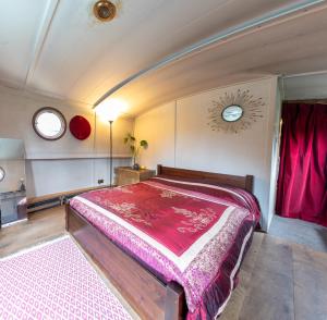 巴斯Off-Grid Living on Spacious Widebeam的一间卧室配有一张带粉红色床单的大床