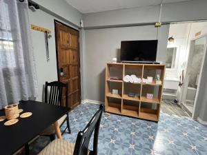 乌隆他尼Udon House的一间带桌子和电视的用餐室