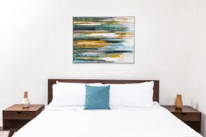 喀巴里特Villa Blue Amber Cabarete的卧室配有白色的床和墙上的绘画作品