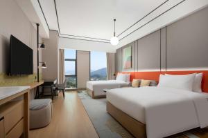 深圳深圳光明虹桥公园希尔顿花园酒店的酒店客房配有两张床和一张书桌
