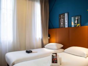 巴黎巴黎蒙马特北18区奥纳诺宜必思酒店的两张睡床彼此相邻,位于一个房间里