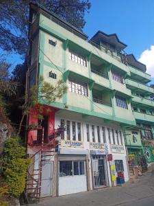 萨加达Pas-it Hostel Sagada的街道上的绿色和白色建筑