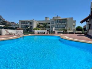 维纳德马Departamento Holiday Park Reñaca 306 Familiar的大楼前的大型蓝色游泳池
