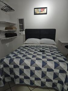 博阿维斯塔Loft lindo, acochegante e reservado的卧室内的一张床位,配有一张 ⁇ 子毯子