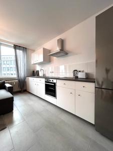 卡塞尔93qm-4 Rooms-WiFi-City Centre的厨房配有白色橱柜和黑色用具