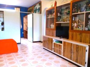 帕皮提Belle Maison F3的一间带电视和木制橱柜的客厅