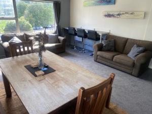 皇后镇Alpine Lodge Queenstown的客厅配有桌子和沙发