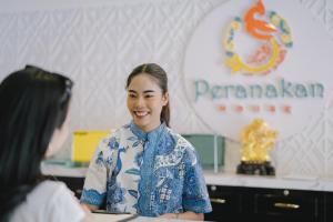 普吉镇Peranakan House - SHA Plus的和另一个女人谈话的女人