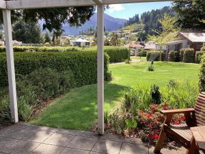 汉默温泉Hanmer Garden Suites的享有带长凳和草坪的花园美景。