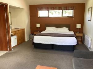 汉默温泉Hanmer Garden Suites的一间卧室设有一张大床和一个窗户。