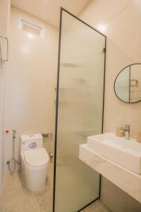 大叻Suri Homestay的一间带卫生间、水槽和镜子的浴室