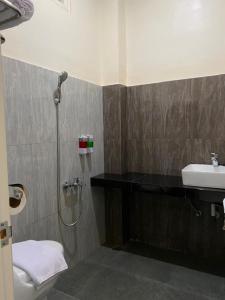 TjolomaduGenio Syariah Hotel Solo的带淋浴和盥洗盆的浴室