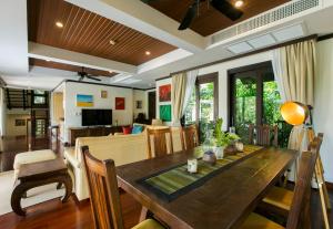 卡塔海滩Katamanda Villa Chanti的用餐室和带木桌的客厅