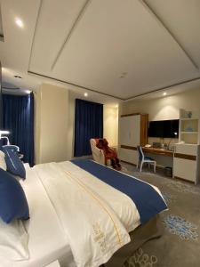 沙鲁拉HOTEL ALFAW PLAZA的一间卧室配有一张大床和一张书桌