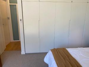 悉尼Seaside Escape的卧室配有白色橱柜和1张床。