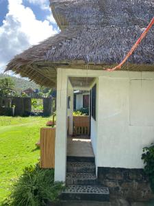 BarasPacific Surf and Yoga的白色的小房子,带有茅草屋顶