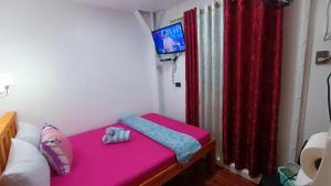 马尼拉MJ Home的小房间设有粉红色的床和红色窗帘