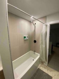 渥太华3 Bedroom Home, 3 Queen Beds, Close To All Amenities的白色的浴室设有浴缸和淋浴。