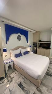 安曼Amman Trail Hotel & Studios的一间卧室设有一张蓝色墙壁的大床