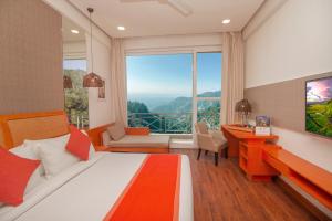 穆索里Yog Wellness Resort & Spa By Amritara的一间卧室配有一张床、一张书桌和一个大窗户