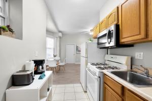 费城Univ City Drexel 2 Bdrm Lovely Unit的厨房配有水槽和炉灶 顶部烤箱