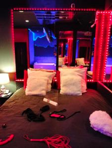 土伦la coquine, love room, romantique的一间卧室配有红色和蓝色的灯光