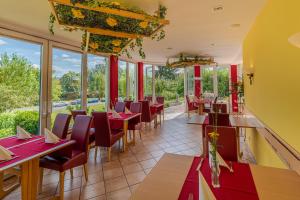 巴特索登-萨尔明斯特艾姆库尔帕克科兹酒店的餐厅设有红色的桌椅和窗户。