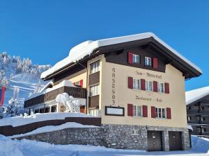 马尔邦Ferienwohnungen Walserhof Malbun的一座大建筑,地面上积雪