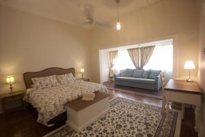 飞鱼湾Divers Villa的一间卧室配有一张床、一张沙发和一个窗口
