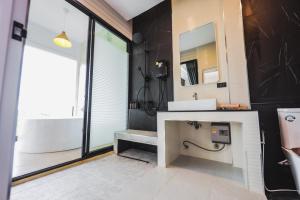 考科Kirin Sky Resort的一间带水槽、浴缸和镜子的浴室