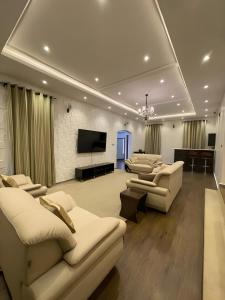 莱基Fedora Luxury Villa in Lekki Phase 1的带沙发和平面电视的客厅