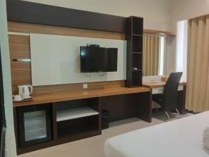沙马林达Violand Garden Hotel Samarinda的一间配备有书桌的客房,配备有一台电视。