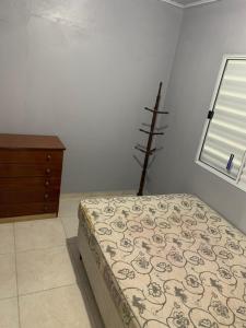 特拉曼达伊Casa de Praia的一间卧室配有一张床、一个梳妆台和一扇窗户。
