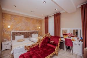 撒马尔罕HOTEL SILK ROAD EMPIRE SAMARKAND的一间卧室配有一张大床和一张红色的沙发