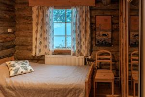 阿卡斯洛姆波罗Hillankukka的一间卧室设有一张床、一个窗口和一把椅子