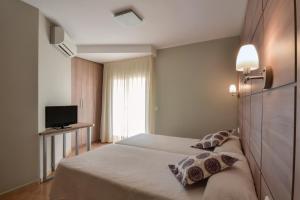 坎布里尔斯El Camí Hotel的酒店客房设有两张床和电视。